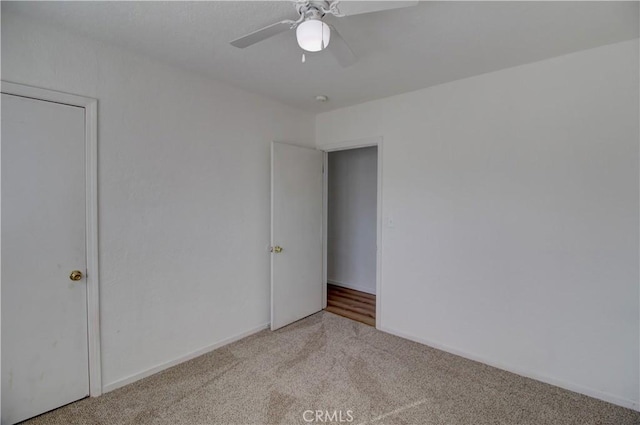 unfurnished bedroom with ceiling fan and light colored carpet