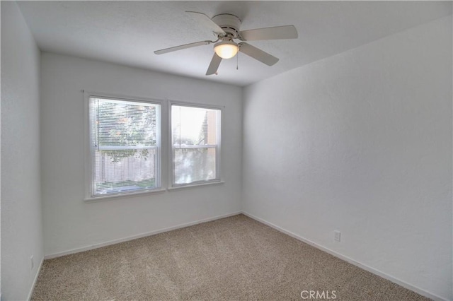 carpeted spare room featuring ceiling fan