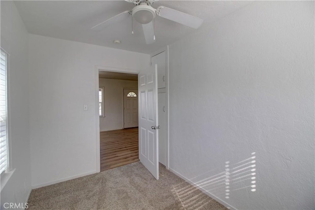 carpeted empty room featuring ceiling fan