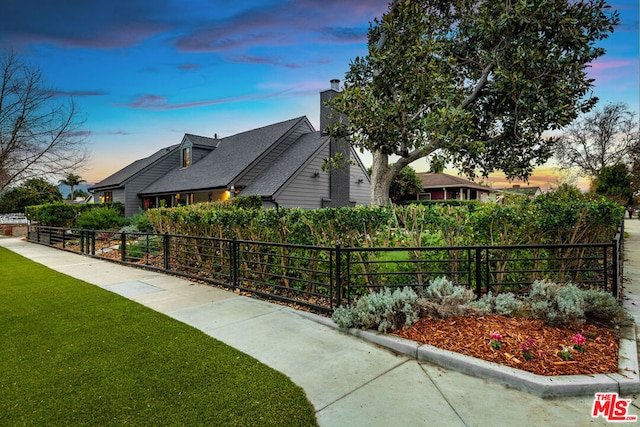 property exterior at dusk with a lawn