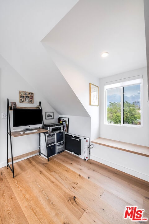 additional living space featuring hardwood / wood-style flooring and vaulted ceiling