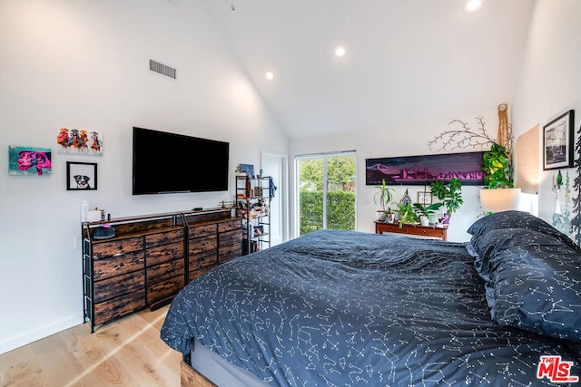 bedroom with hardwood / wood-style floors and high vaulted ceiling