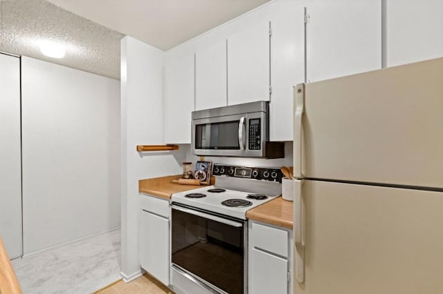 kitchen featuring white cabinetry, white appliances, and a textured ceiling