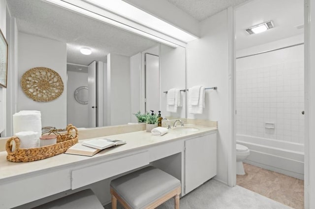 full bathroom featuring tiled shower / bath combo, vanity, a textured ceiling, and toilet