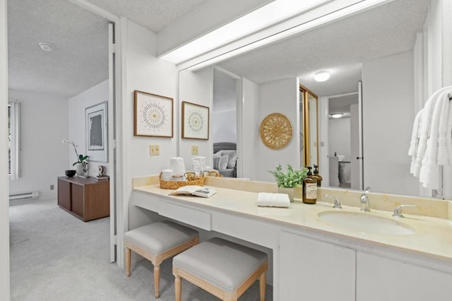 bathroom with vanity, a baseboard radiator, and a textured ceiling