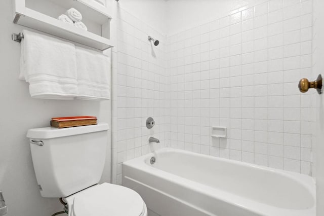 bathroom featuring tiled shower / bath combo and toilet