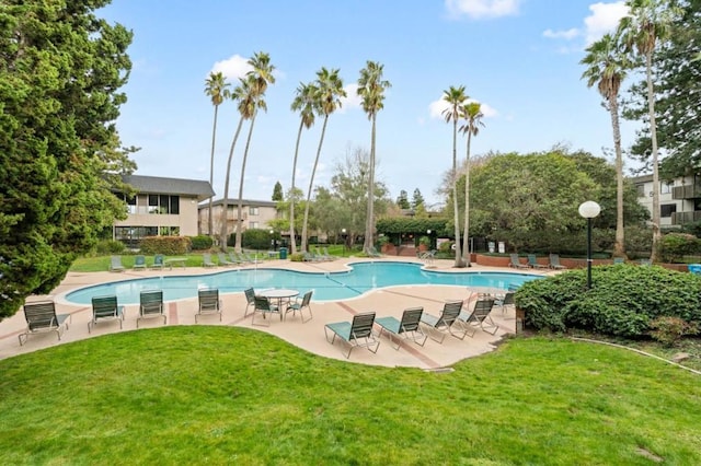 view of swimming pool featuring a lawn and a patio