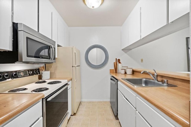 kitchen with stainless steel appliances, white cabinetry, and sink