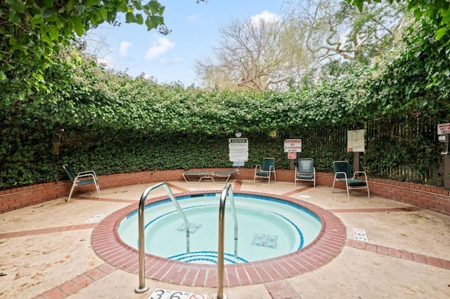 view of pool with a hot tub and a patio