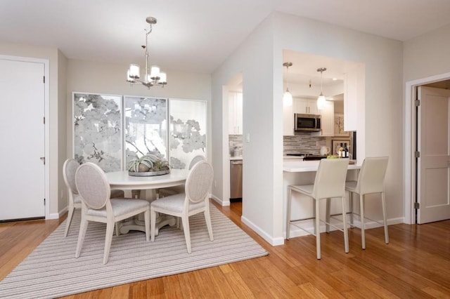 dining area with a notable chandelier and light wood-type flooring