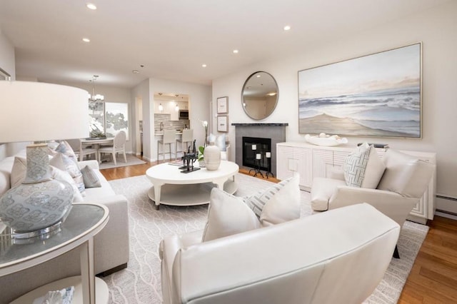 living room with an inviting chandelier and light wood-type flooring