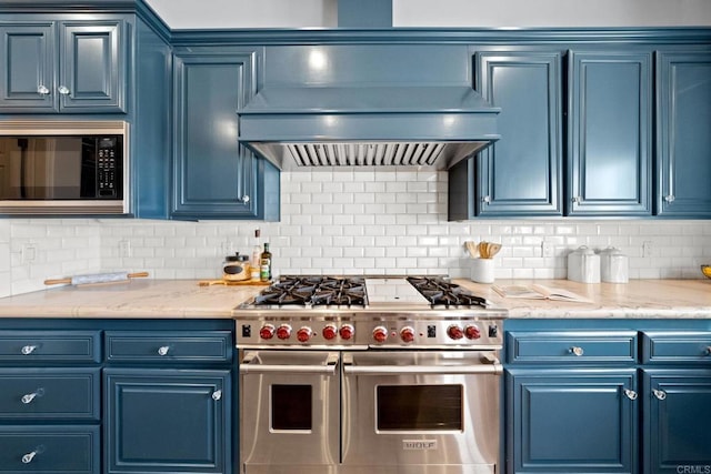 kitchen featuring tasteful backsplash, blue cabinets, built in microwave, custom exhaust hood, and range with two ovens