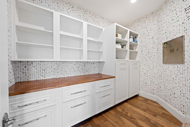 kitchen featuring white cabinetry, dark hardwood / wood-style flooring, and butcher block countertops