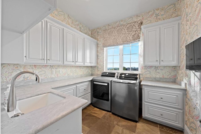 washroom with sink, washer and clothes dryer, and cabinets