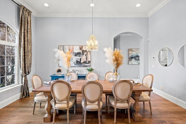 dining space featuring ornamental molding, hardwood / wood-style floors, and an inviting chandelier