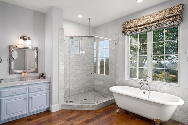 bathroom featuring independent shower and bath, vanity, plenty of natural light, and hardwood / wood-style flooring