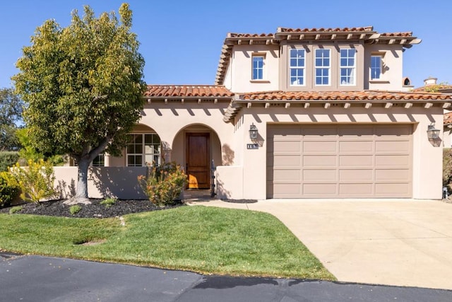 mediterranean / spanish-style home featuring a garage and a front yard