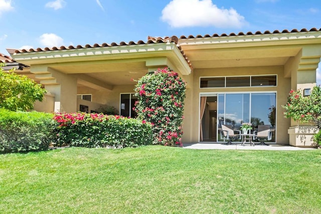 rear view of house with a patio area and a lawn