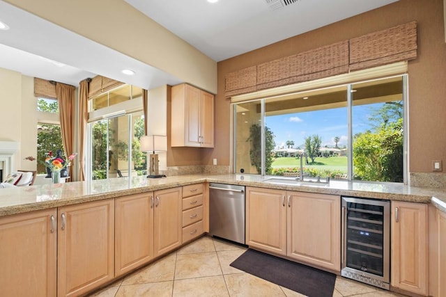 kitchen featuring sink, dishwasher, a wealth of natural light, light brown cabinetry, and beverage cooler