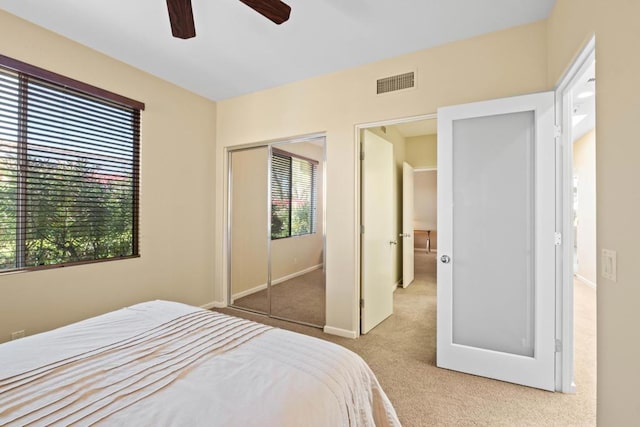 bedroom featuring ceiling fan, a closet, and light carpet