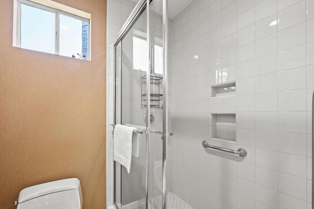 bathroom featuring an enclosed shower and toilet