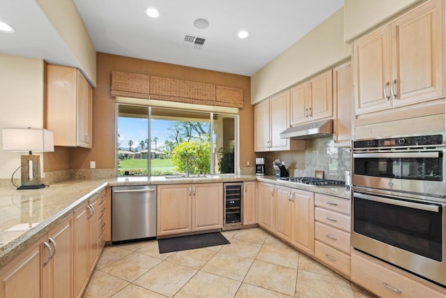 kitchen with sink, appliances with stainless steel finishes, wine cooler, light stone counters, and light brown cabinets