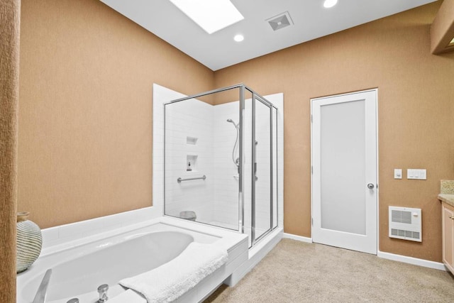 bathroom with shower with separate bathtub, heating unit, vanity, and a skylight