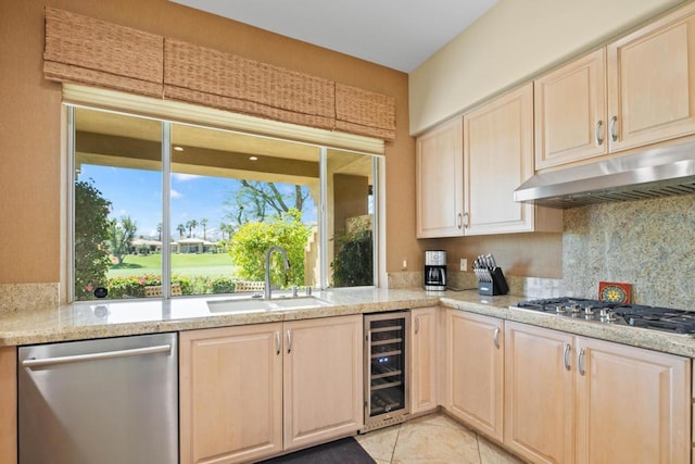 kitchen with sink, beverage cooler, decorative backsplash, stainless steel appliances, and light stone countertops