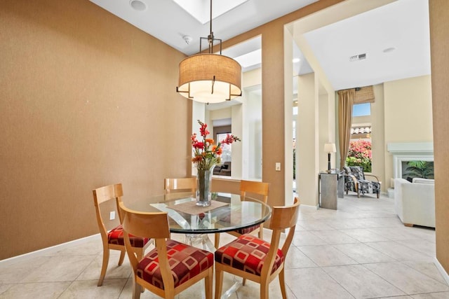 dining room with a towering ceiling and light tile patterned floors