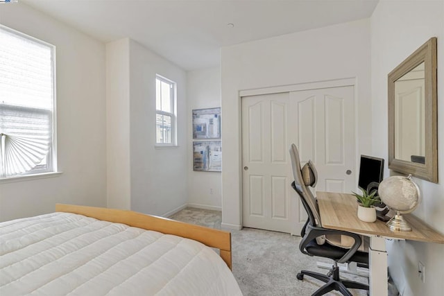 bedroom featuring light colored carpet and a closet