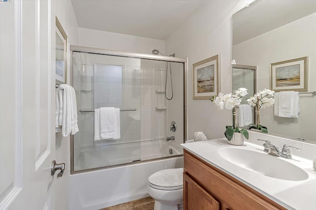 full bathroom featuring vanity, toilet, tile patterned flooring, and combined bath / shower with glass door