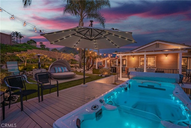 pool at dusk featuring a wooden deck