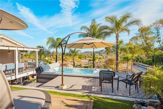 view of swimming pool featuring an outdoor hot tub and a deck with mountain view