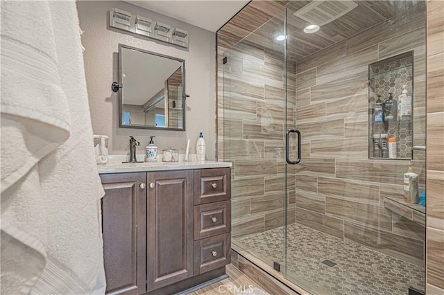 bathroom featuring vanity and a shower with door