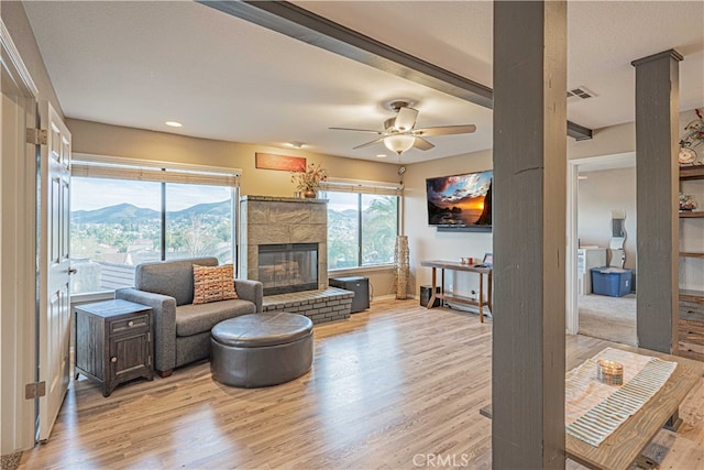 living room with ceiling fan, a mountain view, and light wood-type flooring