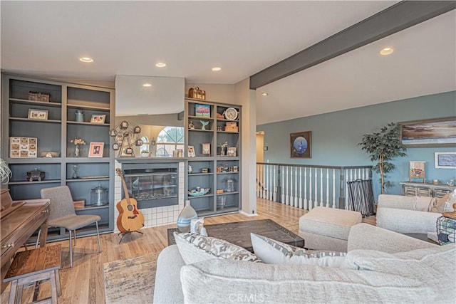 living room featuring a fireplace, hardwood / wood-style floors, and vaulted ceiling with beams