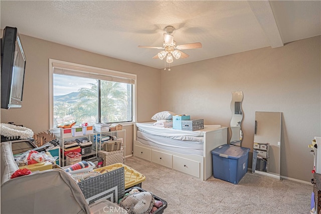 bedroom featuring ceiling fan, light colored carpet, and a textured ceiling