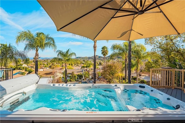 view of pool with a wooden deck and a hot tub