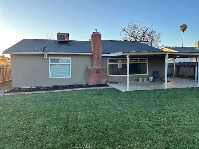 rear view of house featuring central air condition unit, a patio area, and a lawn