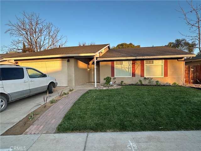 ranch-style house featuring a garage and a front lawn