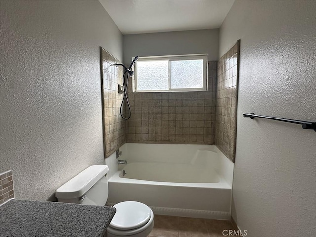 bathroom with tiled shower / bath, toilet, and tile patterned flooring