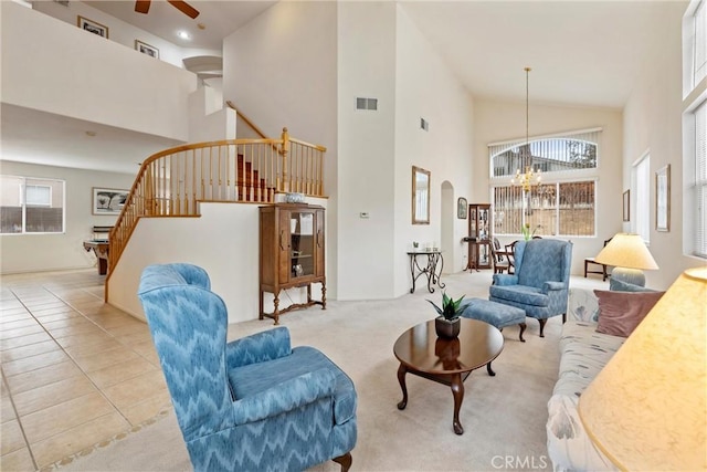 living room with visible vents, arched walkways, stairway, high vaulted ceiling, and light tile patterned flooring