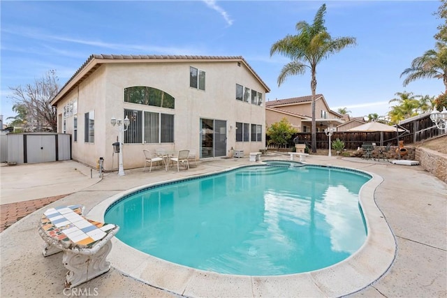 view of swimming pool featuring a fenced backyard, a pool with connected hot tub, and a patio