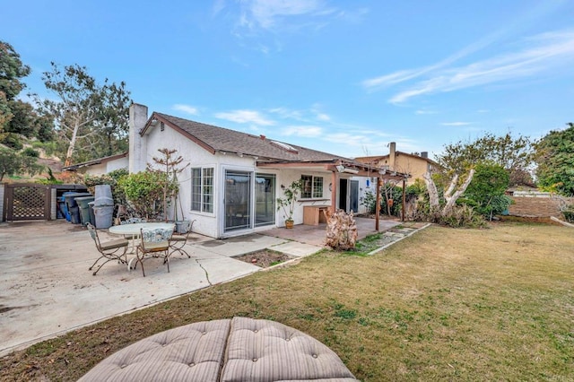 rear view of property with a yard and a patio