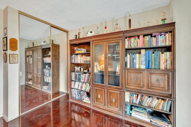 interior space with a textured ceiling and dark hardwood / wood-style flooring