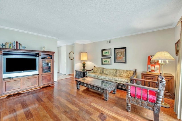 living room featuring hardwood / wood-style flooring, ornamental molding, and a textured ceiling