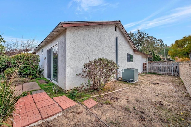 view of side of home with central AC and a patio area