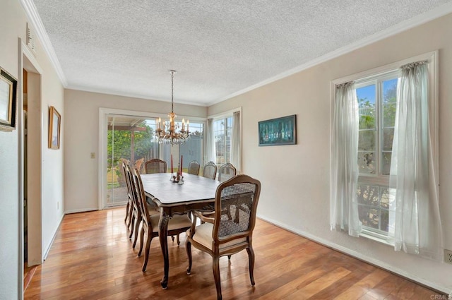 dining room with crown molding, an inviting chandelier, a textured ceiling, and light hardwood / wood-style floors