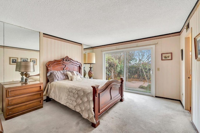 bedroom with access to outside, light colored carpet, and a textured ceiling