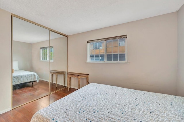 bedroom featuring hardwood / wood-style flooring, a closet, and a textured ceiling